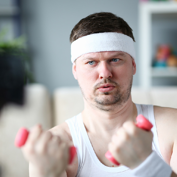 Harry Smith in the gym with his workout clothes on holding weights.